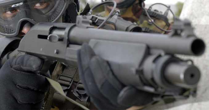 Holding a shotgun